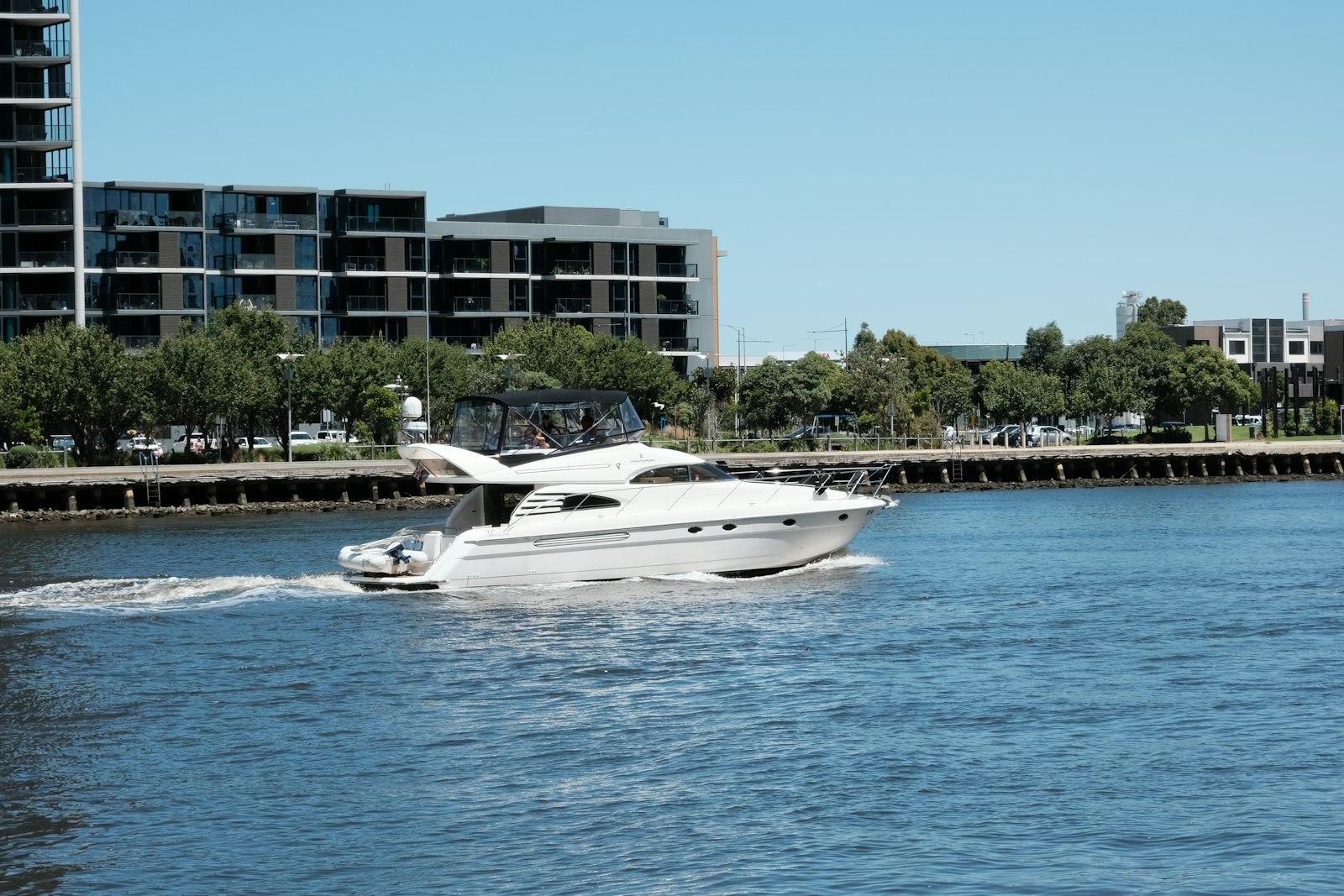 Motor yacht cruising a city waterfront after a lake day — the evening guests still need to plan