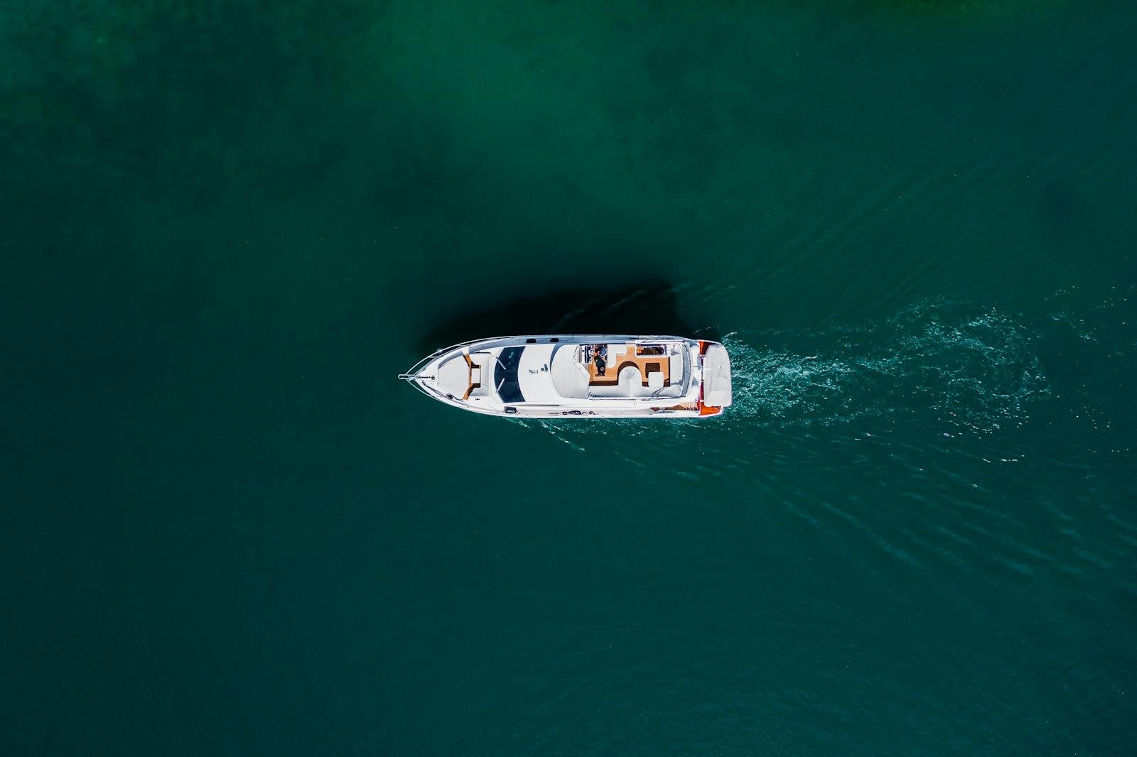 Aerial view of a white motorboat underway — the paid charter before guests look at evening tickets